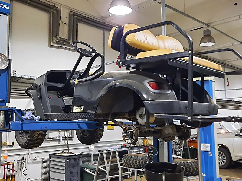 Reparatur des MINICAR Golfcars auf der Hebebühne im Service